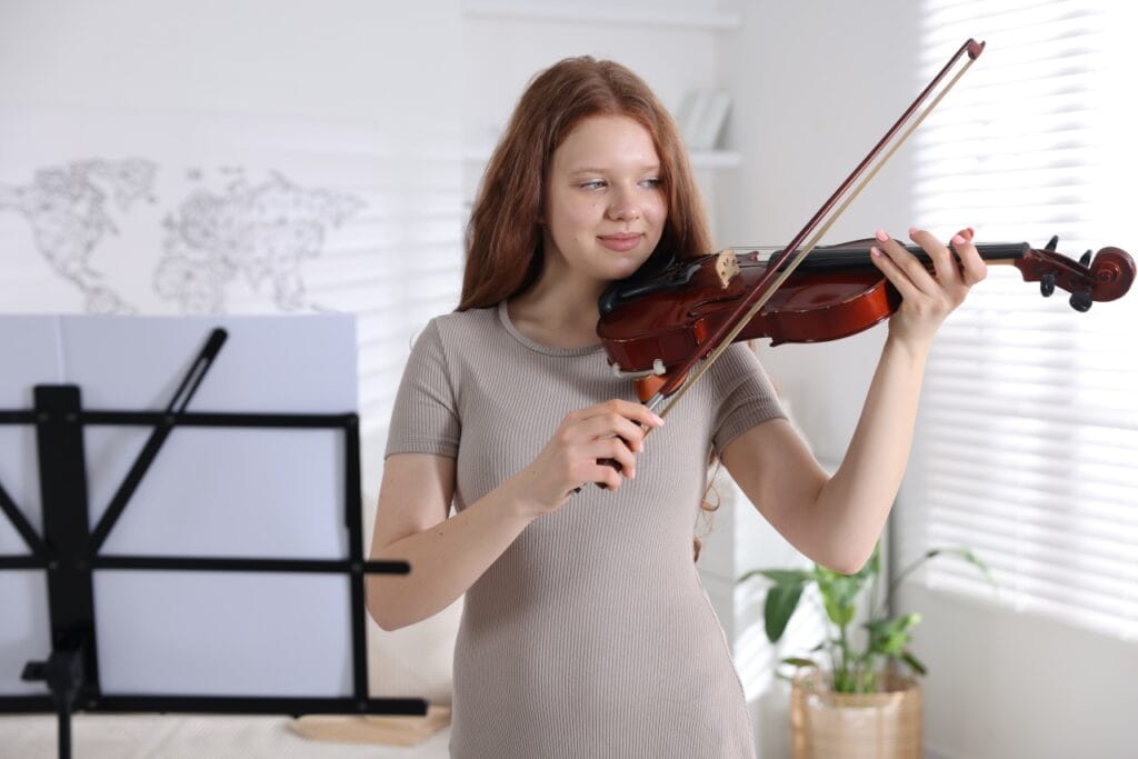 fată cântând la vioară acustică, arcuș și sacâz pentru sunet clar