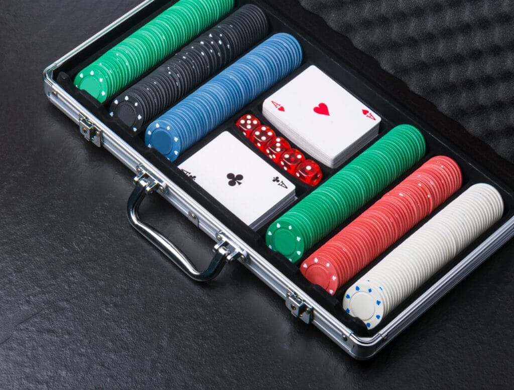 servietă din aluminiu cu jetoane de poker, cărți de joc și zaruri organizate